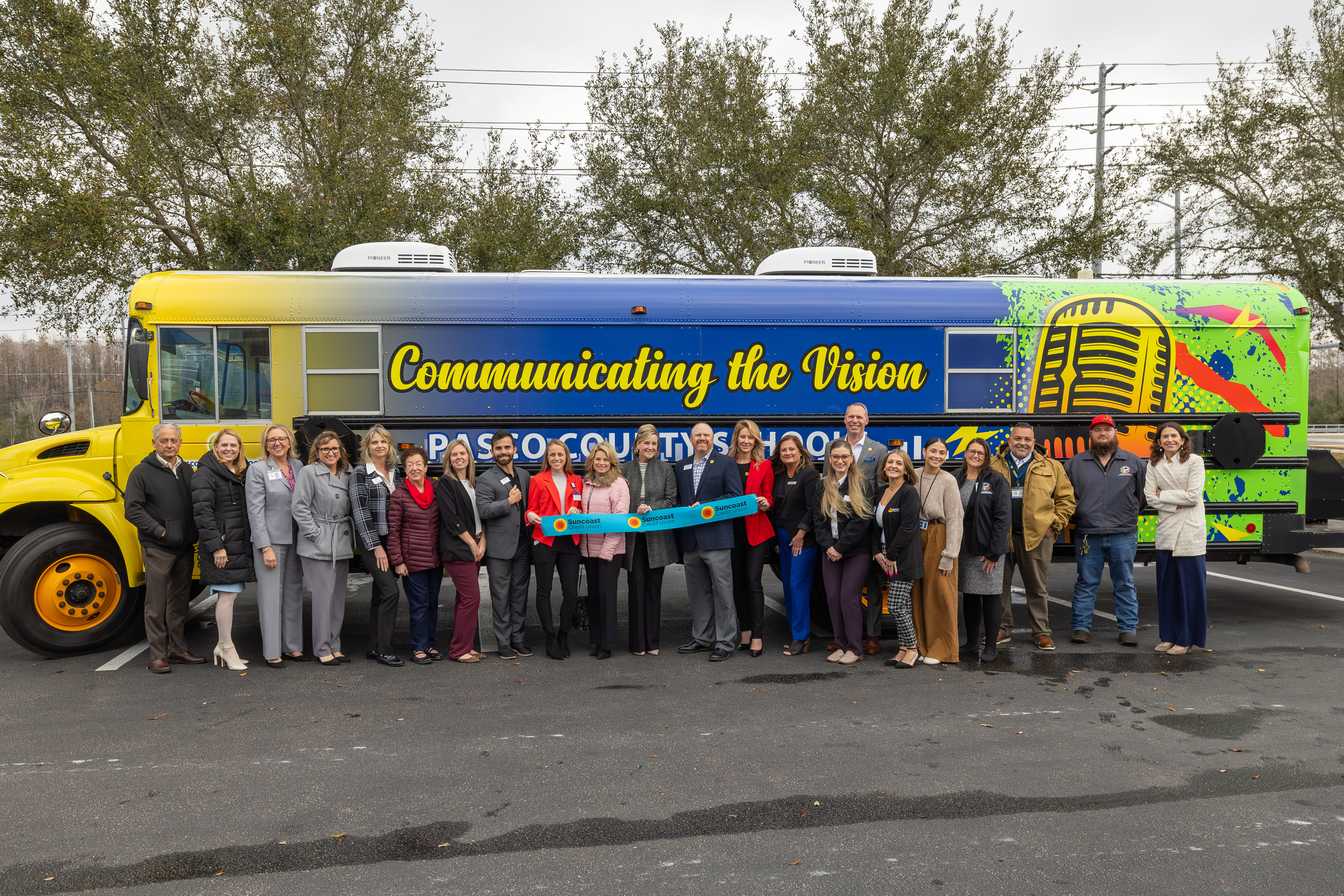 District and community members standing in front of the Communicating the Vision podcast bus