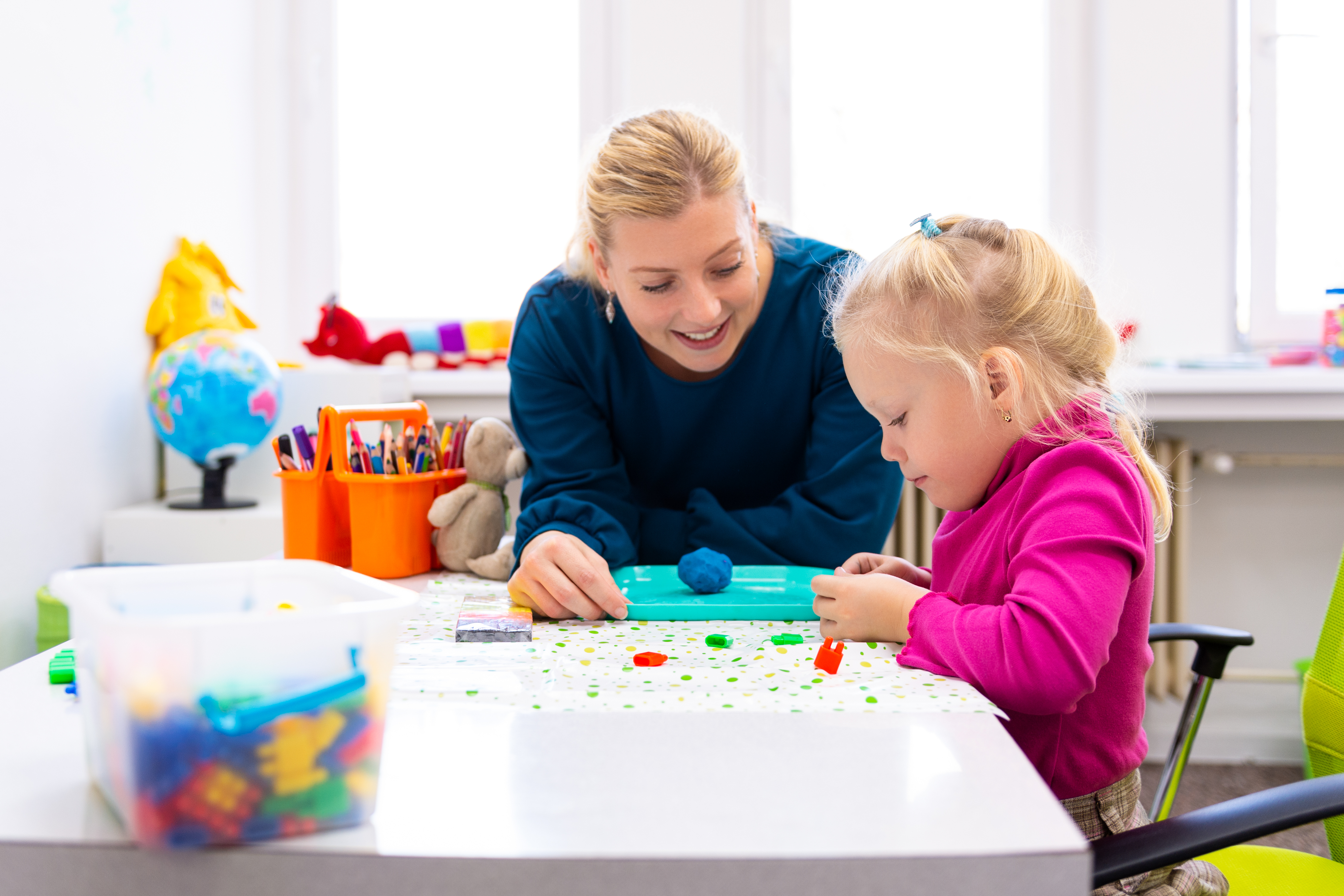A therapist or teacher working with a student